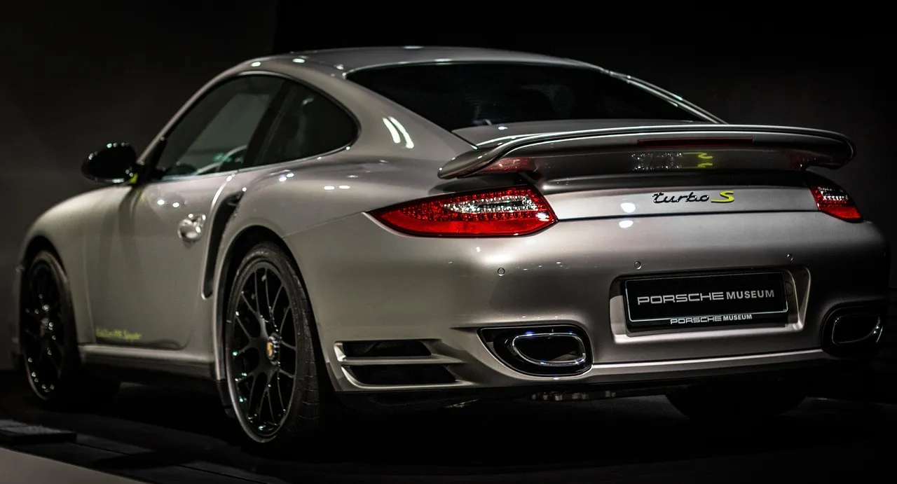 Silver sports car photographed from the rear three-quarter angle