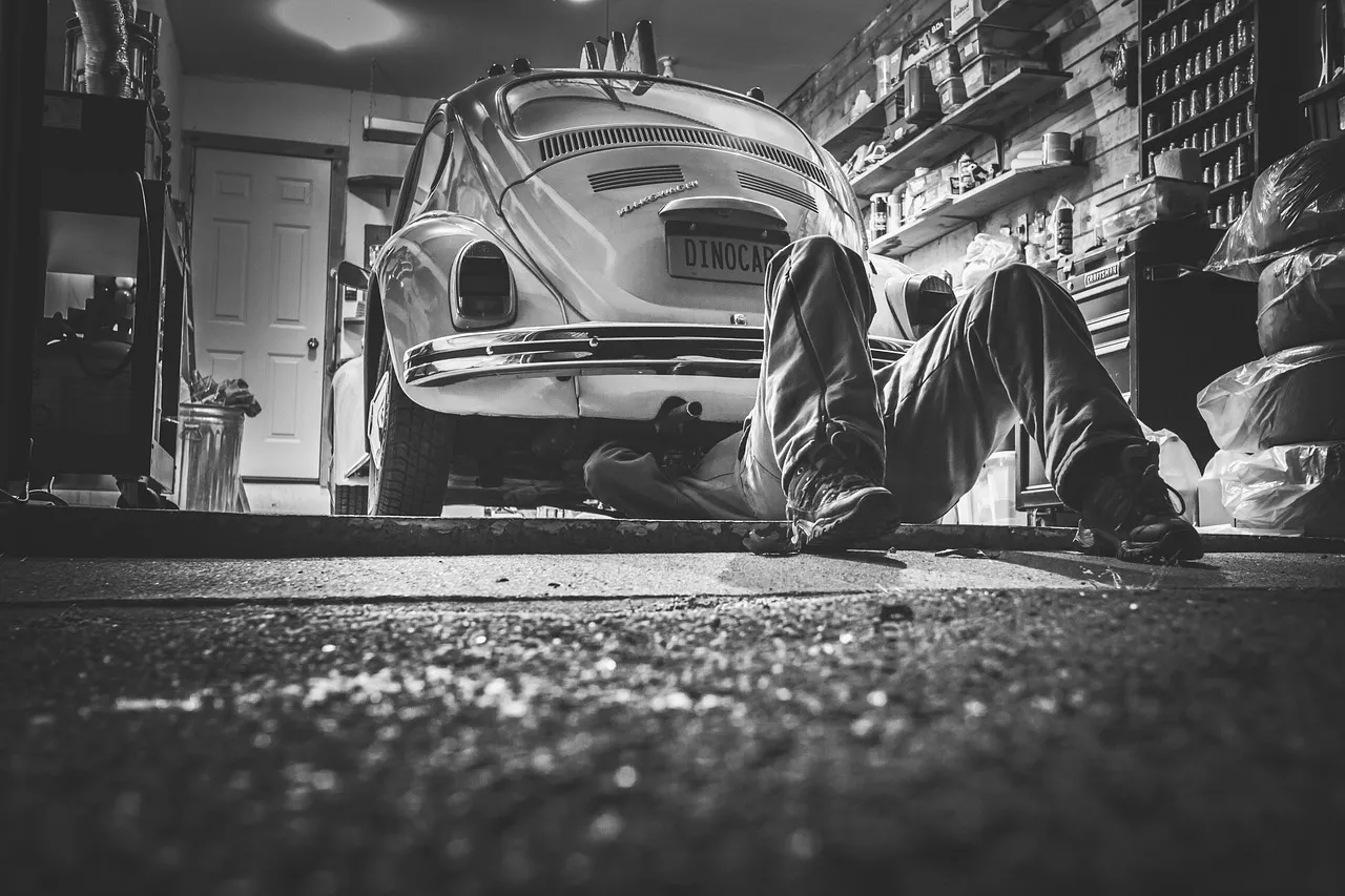 Mechanic working underneath a classic car