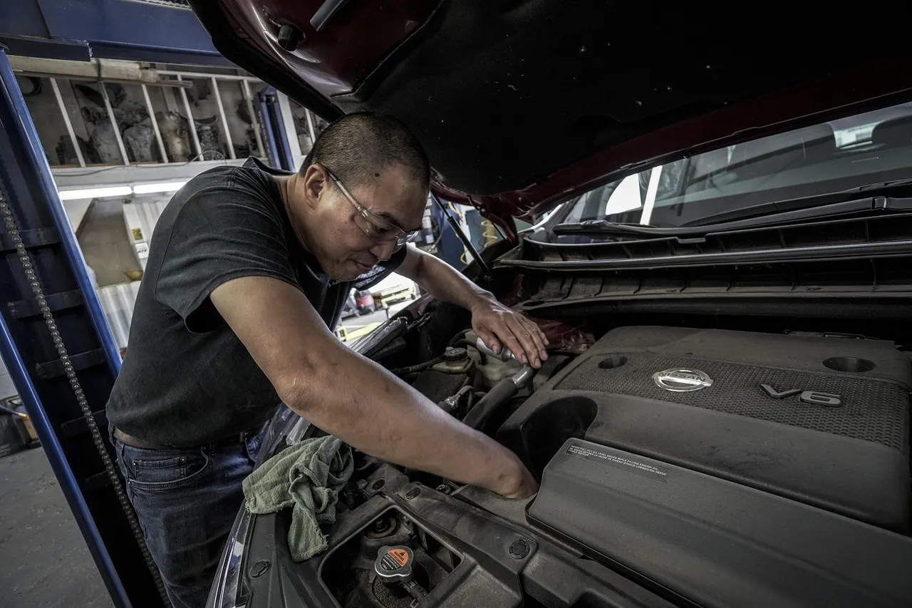 Mechanic leaning over an engine bay with tools